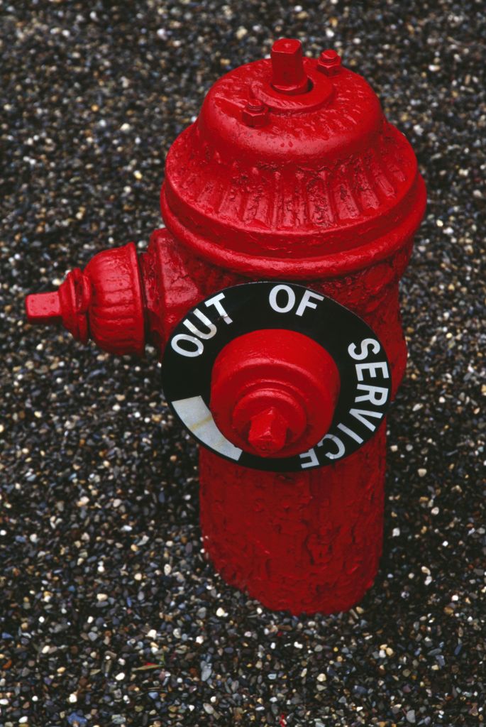 Red fire hydrant, out of service after water main break