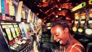 Young woman winning money from slot machine, profile