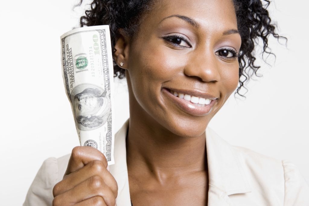 African American woman holding hundred dollar bill