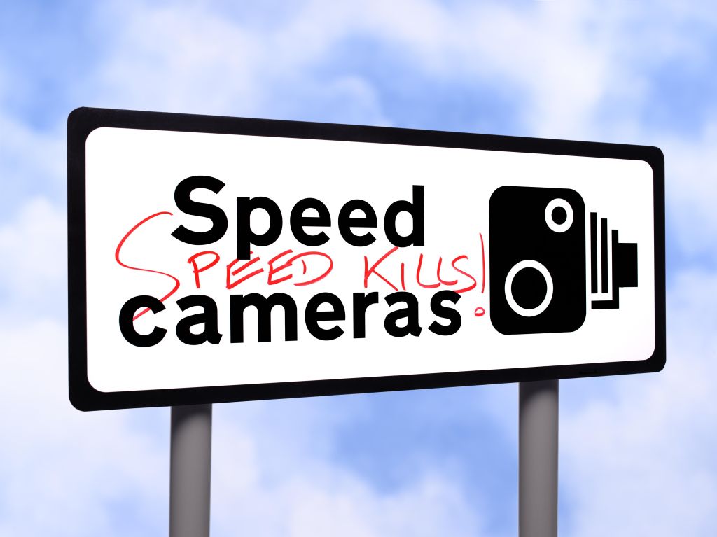 Speed camera sign with graffiti