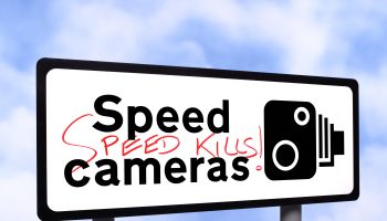 Speed camera sign with graffiti