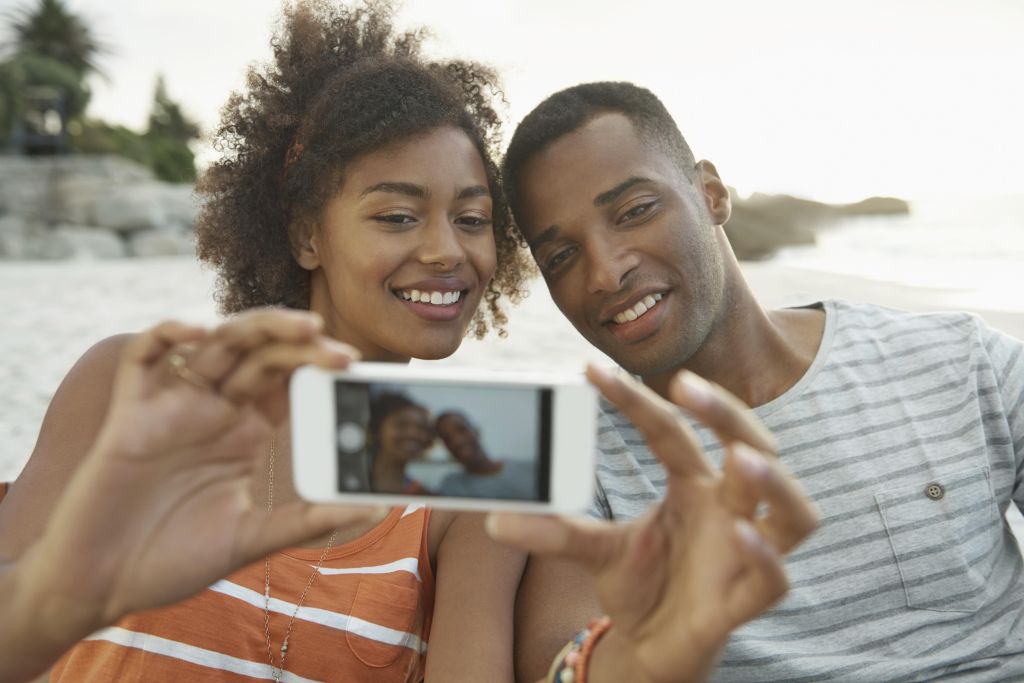 A young couple taking a selfie with a smartphone camera