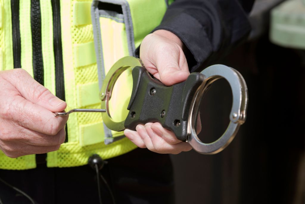 Close up of police officer holding the key to a pair of handcuffs