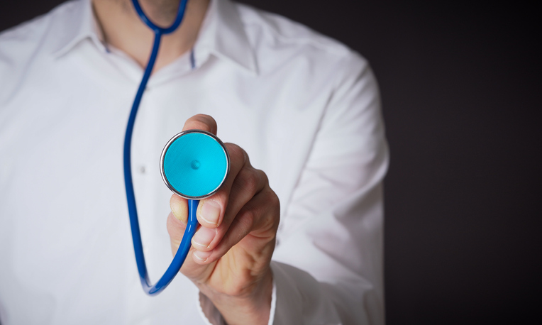 Midsection Of Doctor Holding Stethoscope Against Black Background