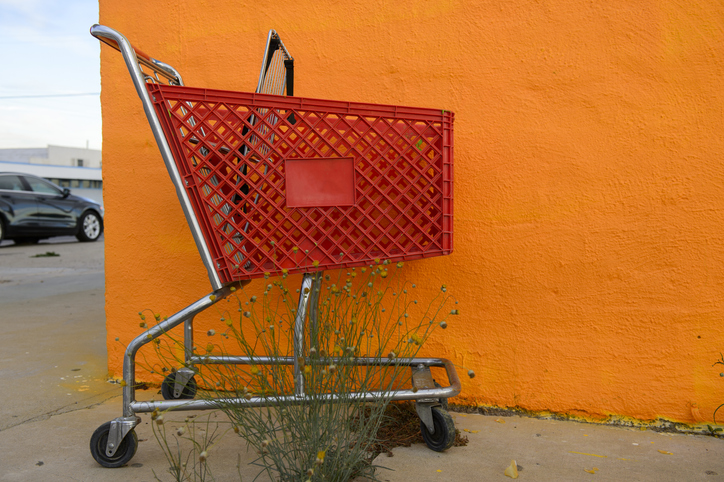 A red shopping cart in front a orang colored wall at Fort Stockton, Texas, USA