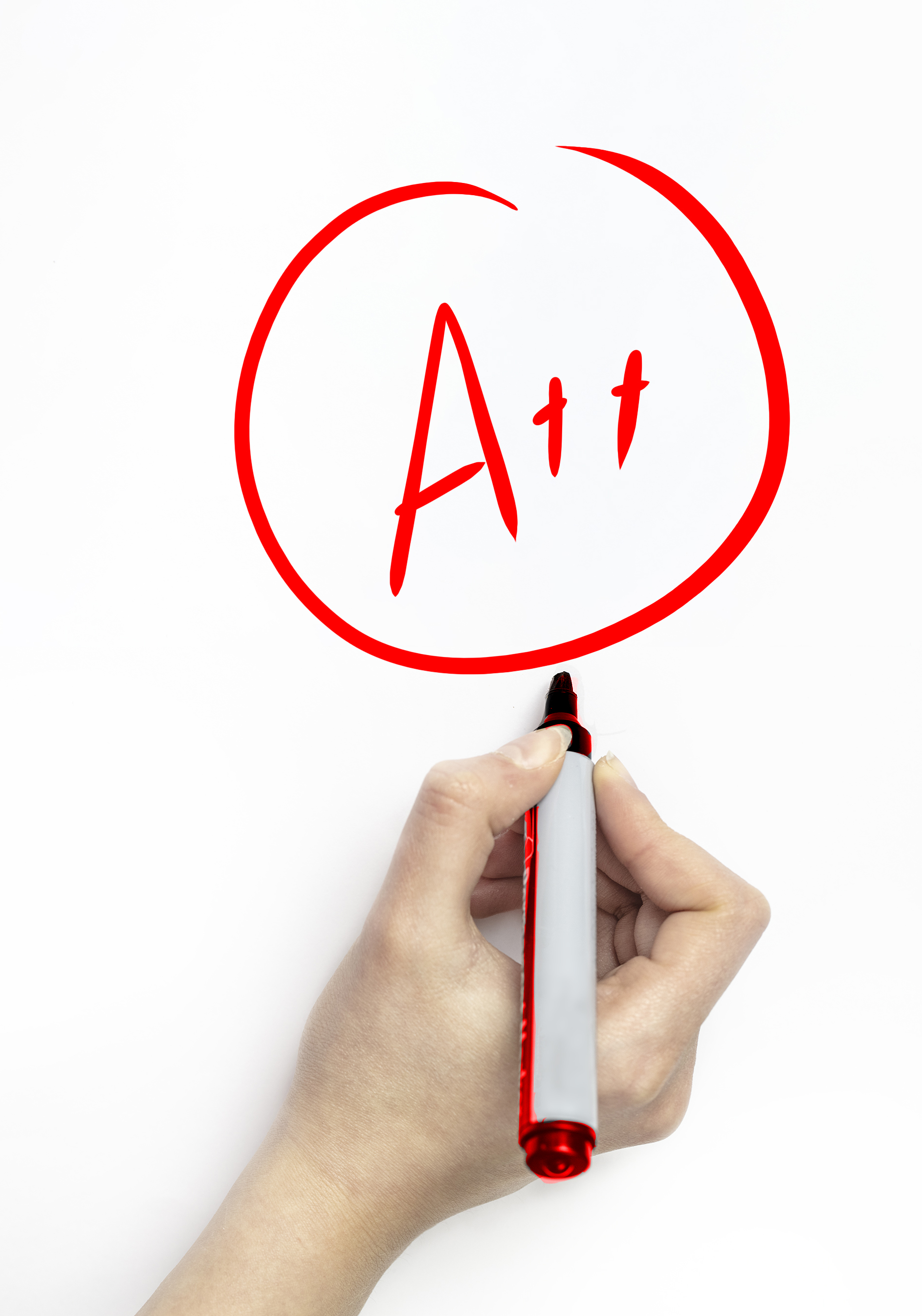 Hand grading a student with red marker on white page