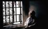 An elderly woman enjoys the sunlight from a window, 4 April 1996. AFR Picture b