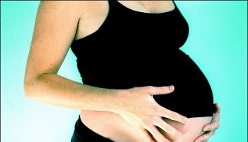 A pregnant woman holds her belly, 12 July 2002. AFR Picture by LOUISE KENNERLEY