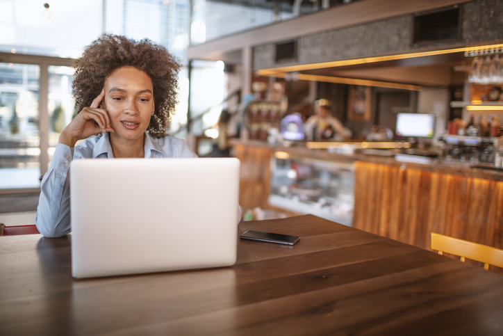 Young woman using laptop at the bar