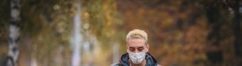 Young man with protective face mask on her way to training