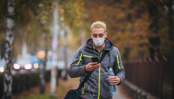 Young man with protective face mask on her way to training