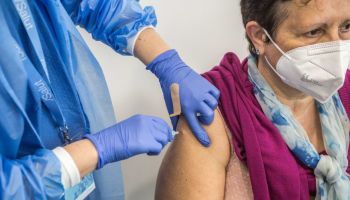 Woman receives a dose of the COVID19 Vaccine at Fira...