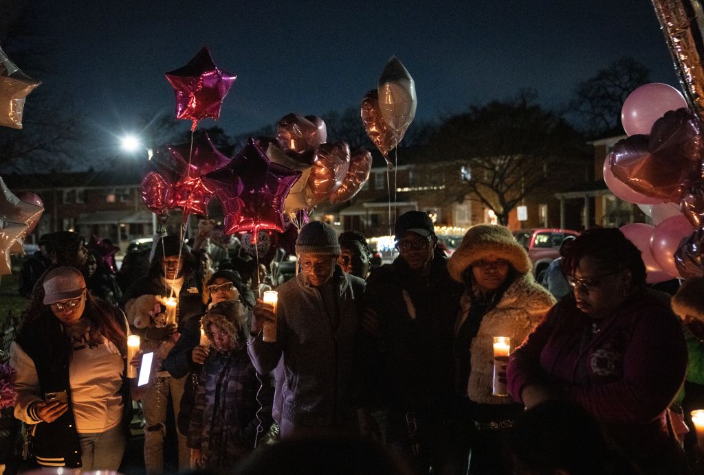 Family members and neighbors gather at the vigil for 11-year-old London Olsen in Essex on Tuesday evening.