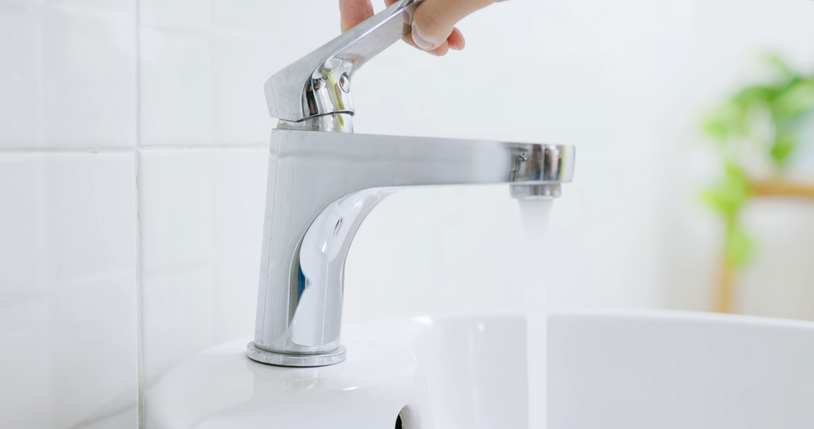 asian people turning on faucet