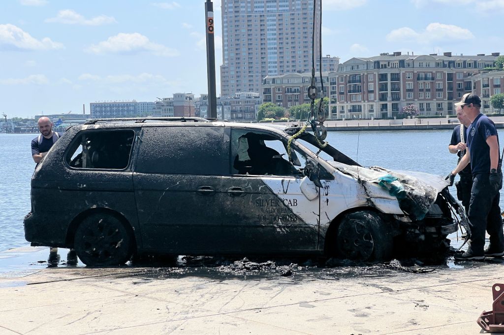 Baltimore City Fire Department and the Baltimore Police Underwater Recovery Team pull a van from the Inner Harbor on Thursday.